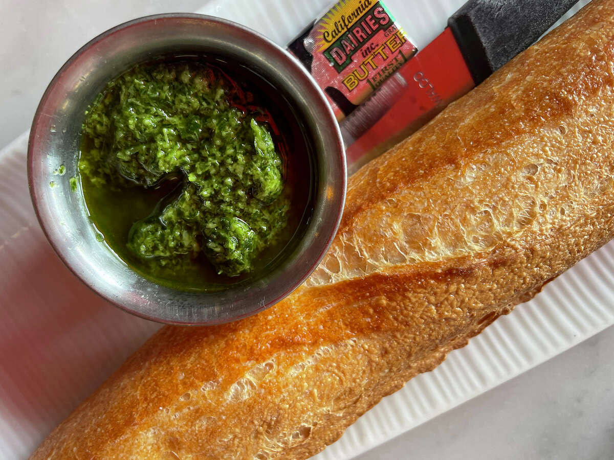 Fresh baked baguette with garlic relish at the Stinking Rose in San Francisco, on Thursday, May 25, 2023.